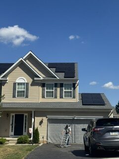 Roofing work shown with rooftop solar panels