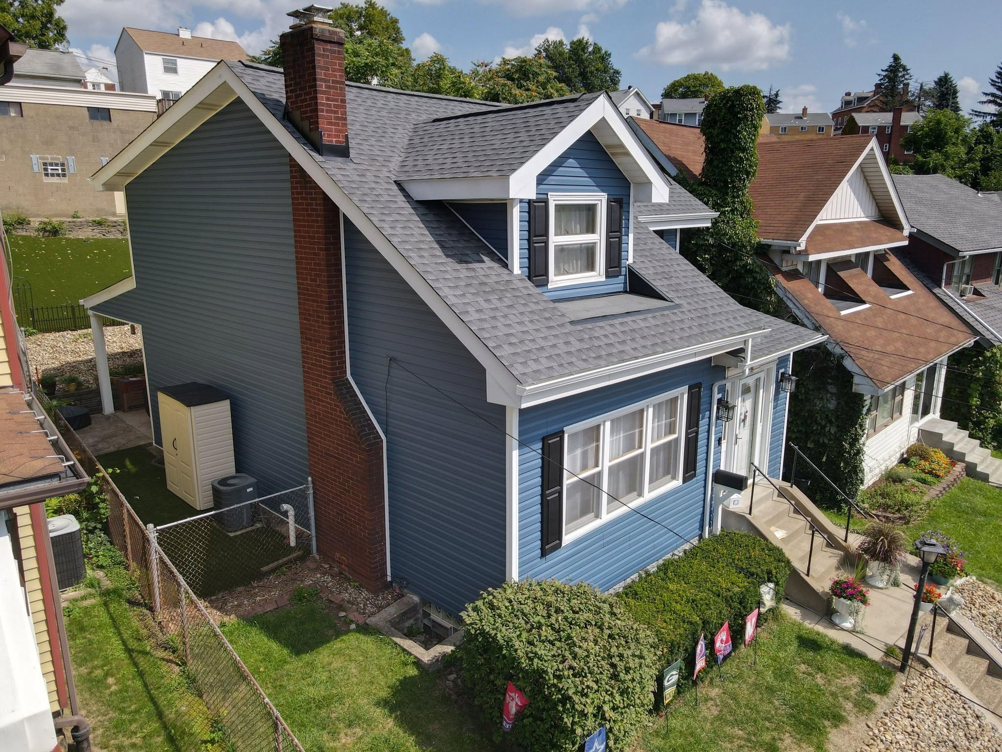 Completed gray architectural shingle roof on a blue home