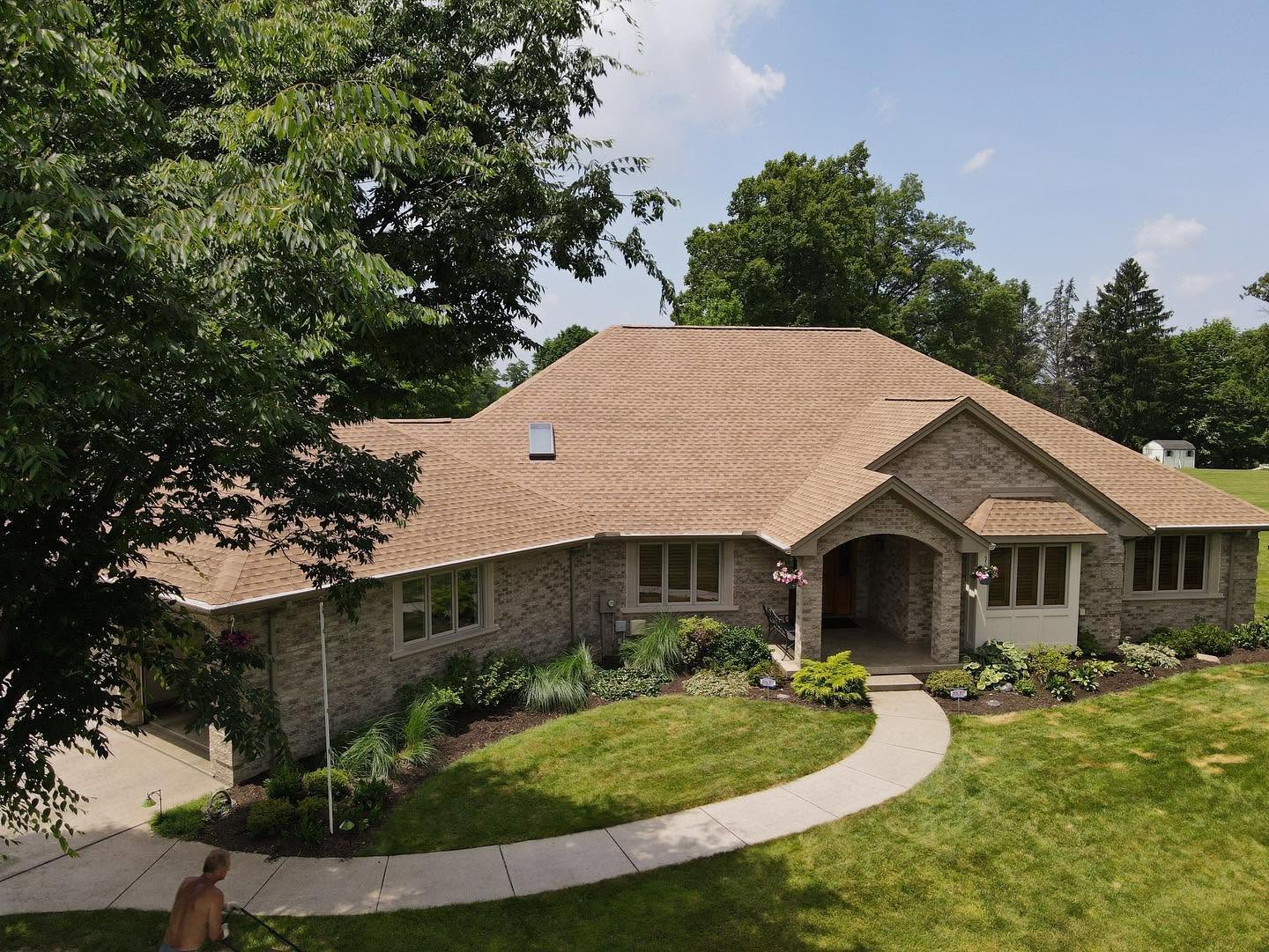 Wide view of a completed tan shingle roofing system